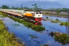 Salah satu rangkaian kereta api terlihat melintas pelan saat melewati banjir di potong, Sidoarjo, Selasa (17/6/2025). (Foto : Eleanor/tagarjatim.id)