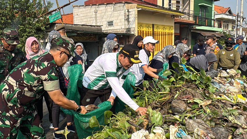 Bupati Sidoarjo Subandi bersama Dandim 0816/Sidoarjo, Anggota DPRD Sidoarjo dan masyarakat bahu membahu membersihkan aliran sungai pelayaran, Sabtu (21/6/2025). (Foto : Eleanor)