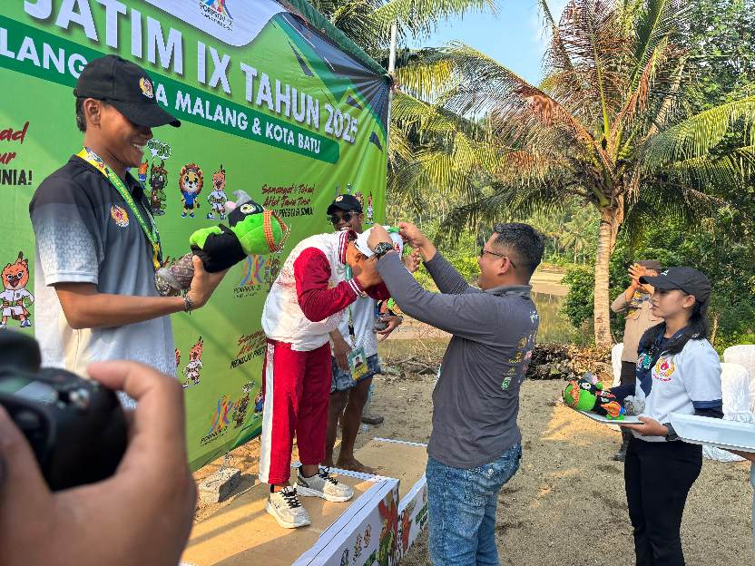 Kapolres Malang AKBP Danang Setiyo P. S., saat mengalungkan medali kepada pemenang di cabor selancar ombak Porprov Jawa Timur IX Tahun 2025, (21/6/2025) (Dok. Humas Polres Malang)