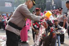 Kapolresta Malang Kota, Kombes Nanang Haryono memberikan guyuran air kembang kepada anggota yang naik pangkat (Istimewa)