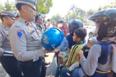 Personil Satlantas Polres Jombang membagikan helm kepada pengendara selama operasi patuh (Istimewa)