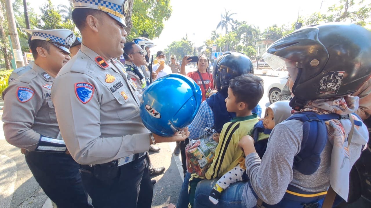Personil Satlantas Polres Jombang membagikan helm kepada pengendara selama operasi patuh (Istimewa)