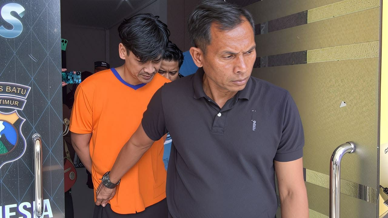 Pelaku Brimob gadungan saat digelandang petugas Polres Batu.