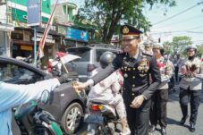 Kasatlantas Polres Malang, AKP Muhammad Alif Chelvin sedang membagikan bendera pada pengunajalan (17/8/2025) (Istimewa)