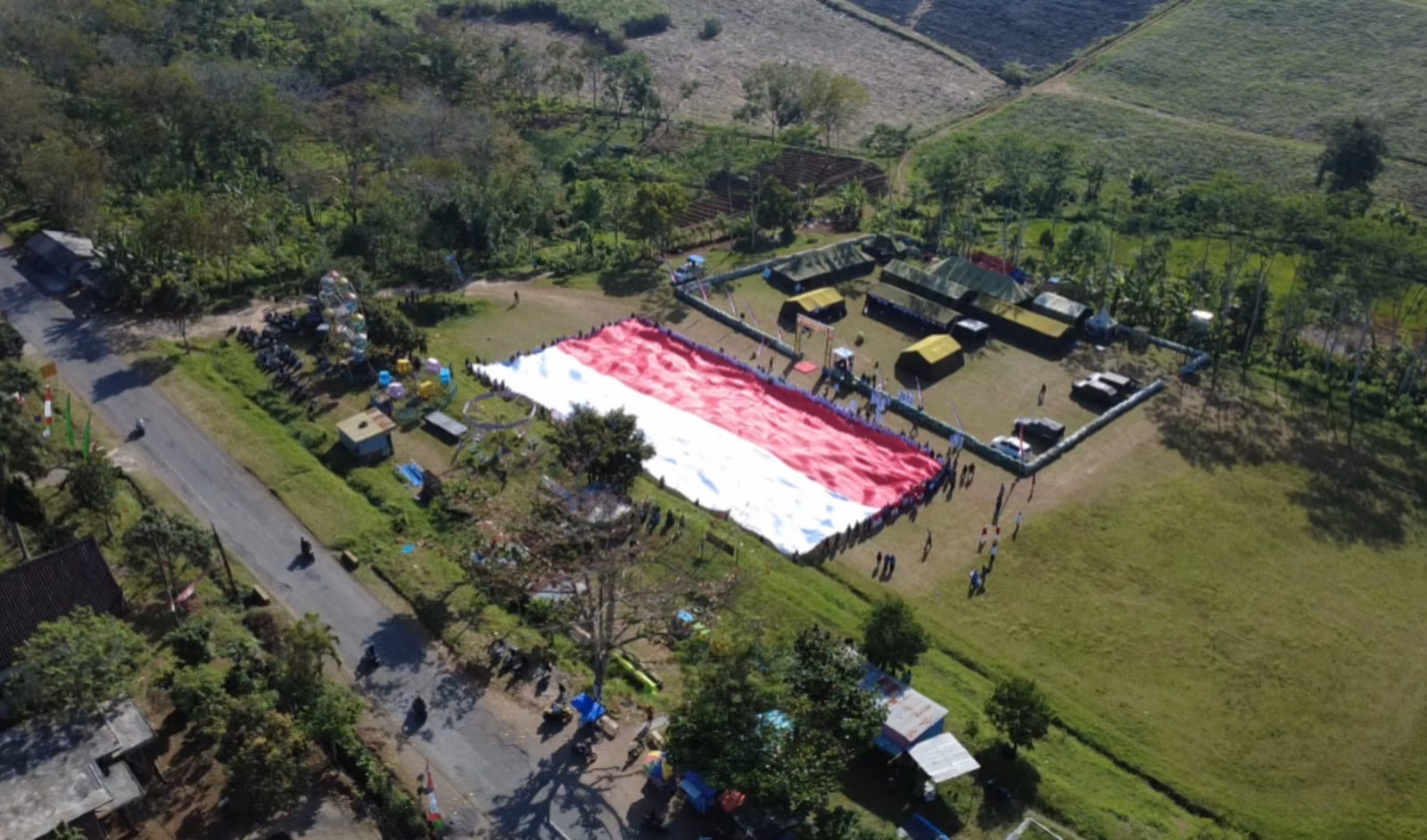 Bendera raksasa yang dibentangkan di lapangan Margomulyo, Desa Harjokuncaran, Kecamatan Sumbermanjing Wetan, Kabupaten Malang (Fajar Nusantara/ Tagarjatim.id)