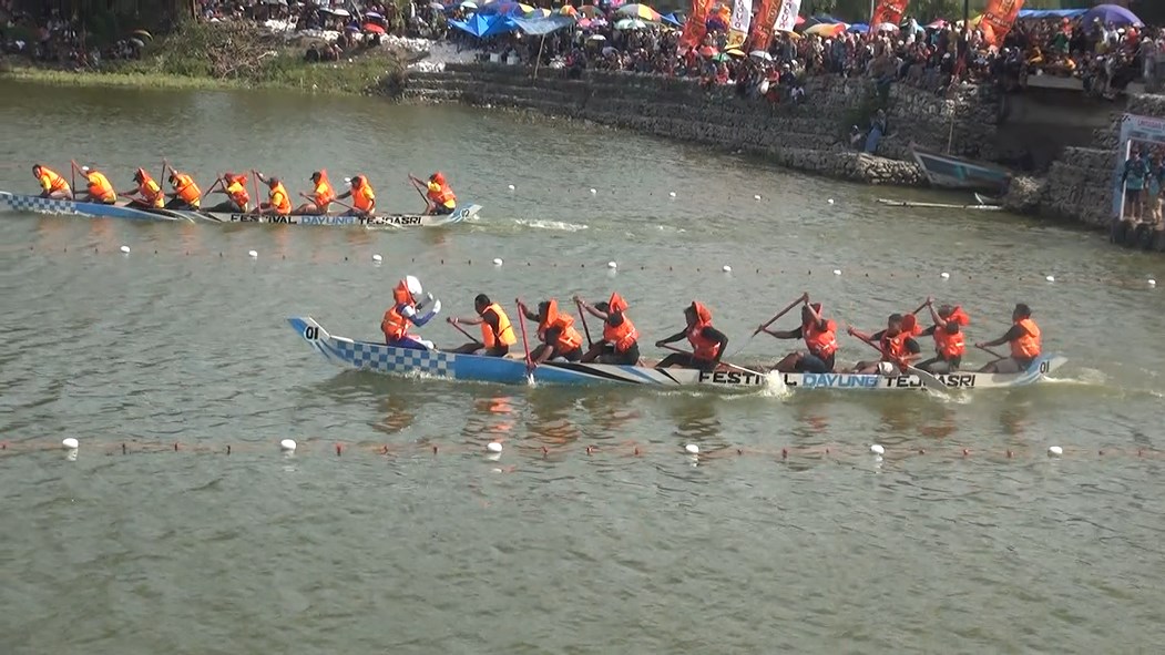 Ultraman menjadi pacu jalur dayung saat lomba dayung di Sungai Bengawan Solo di Desa Tejoasri Kecamatan Laren, Lamongan.