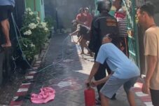 sejumlah warga berusaha padamkan api dengan alat seadanya