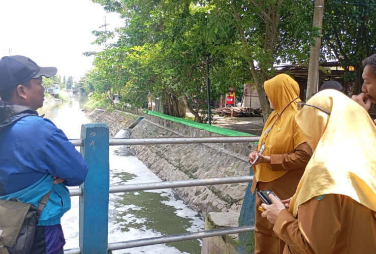 Petugas DLKH sedang meninjau lokasi sungai yang diduga tercemar limbah B3, Senin (19/01)2026). (Robi/ Tagarjatim.id)