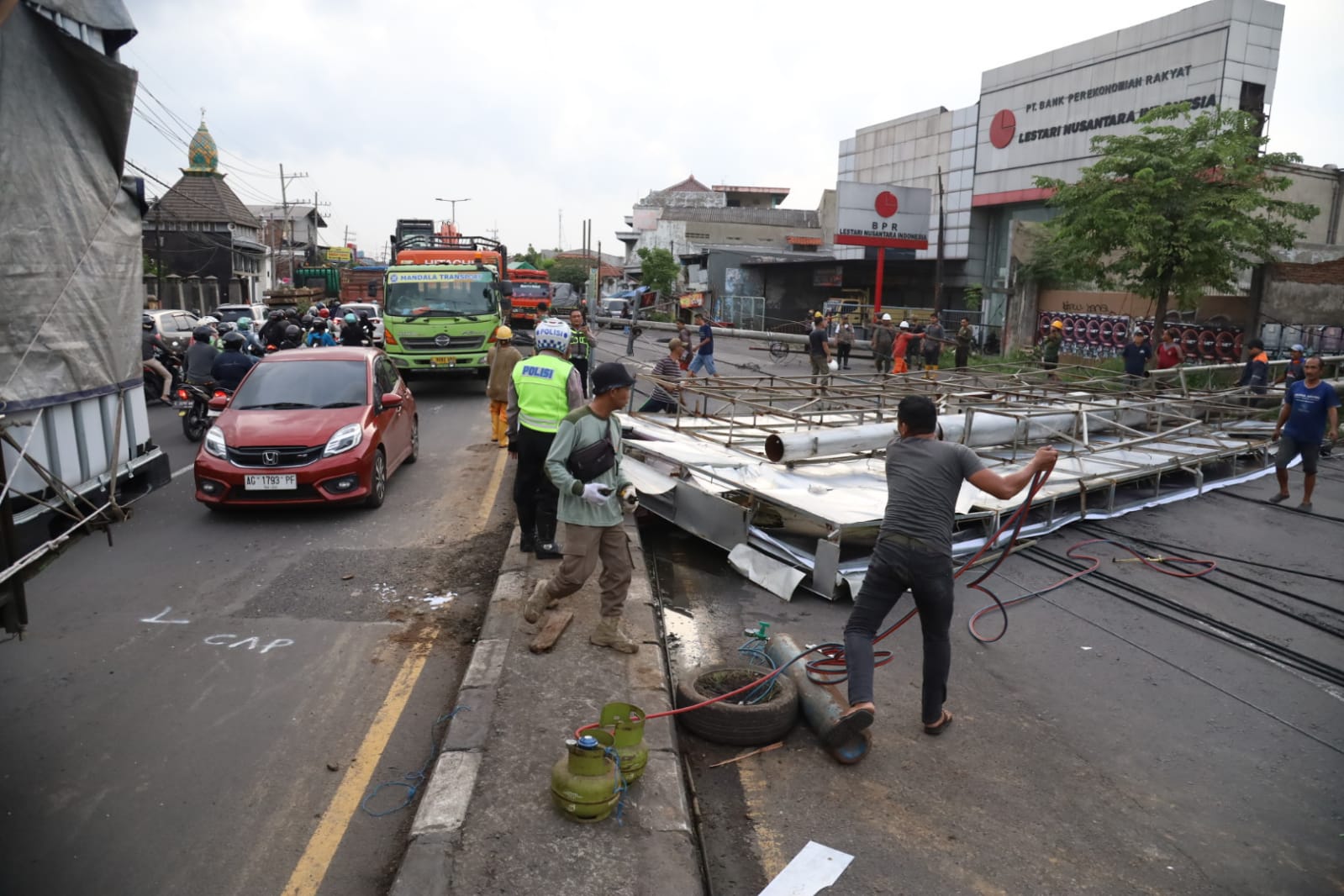 Tiga Tiang Listrik dan Reklame Ambruk di Jalan Raya Gilang Taman, Jalur Surabaya–Mojokerto Macet Panjang